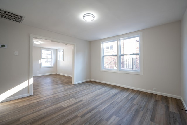 spare room featuring dark hardwood / wood-style flooring and a wealth of natural light