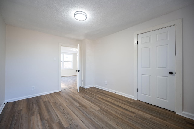 unfurnished room with dark hardwood / wood-style floors and a textured ceiling