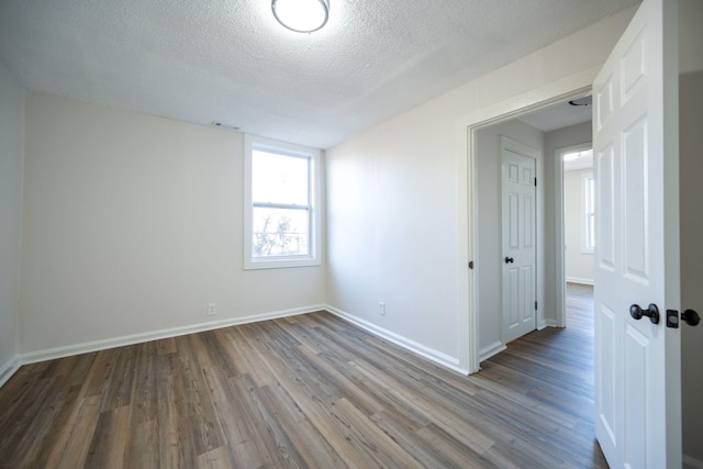 empty room with a textured ceiling and hardwood / wood-style flooring