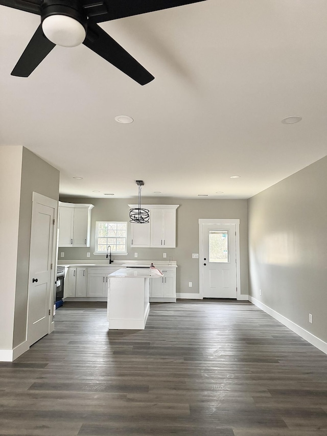 kitchen with sink, decorative light fixtures, dark hardwood / wood-style flooring, a kitchen island, and white cabinets