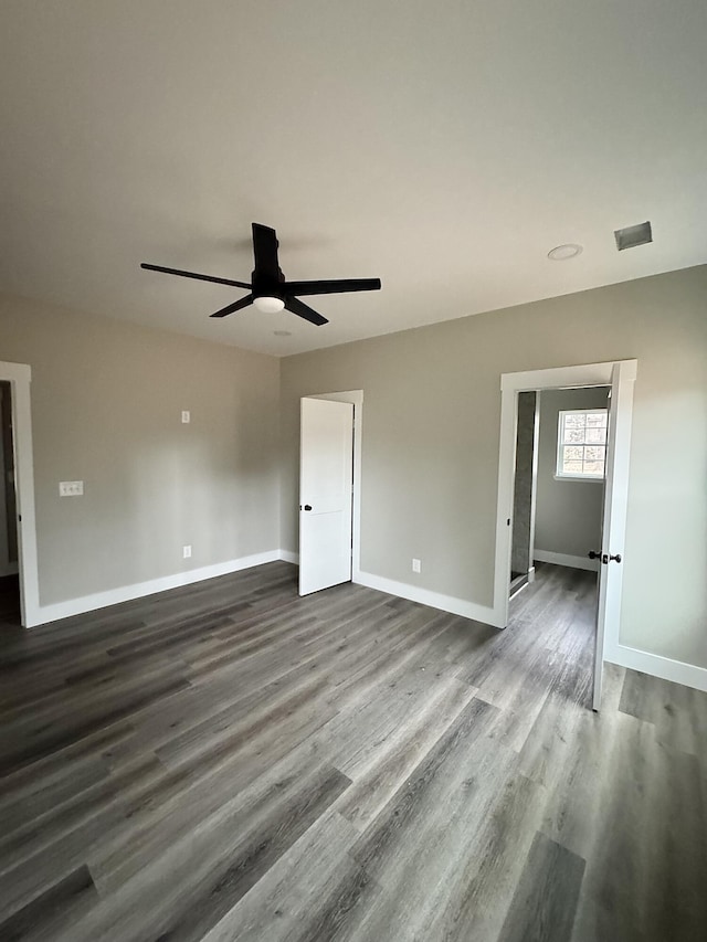 unfurnished room featuring dark wood-type flooring and ceiling fan