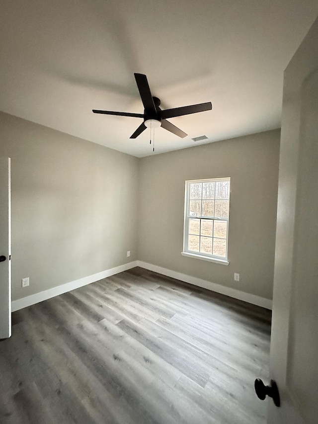 spare room with dark wood-type flooring and ceiling fan