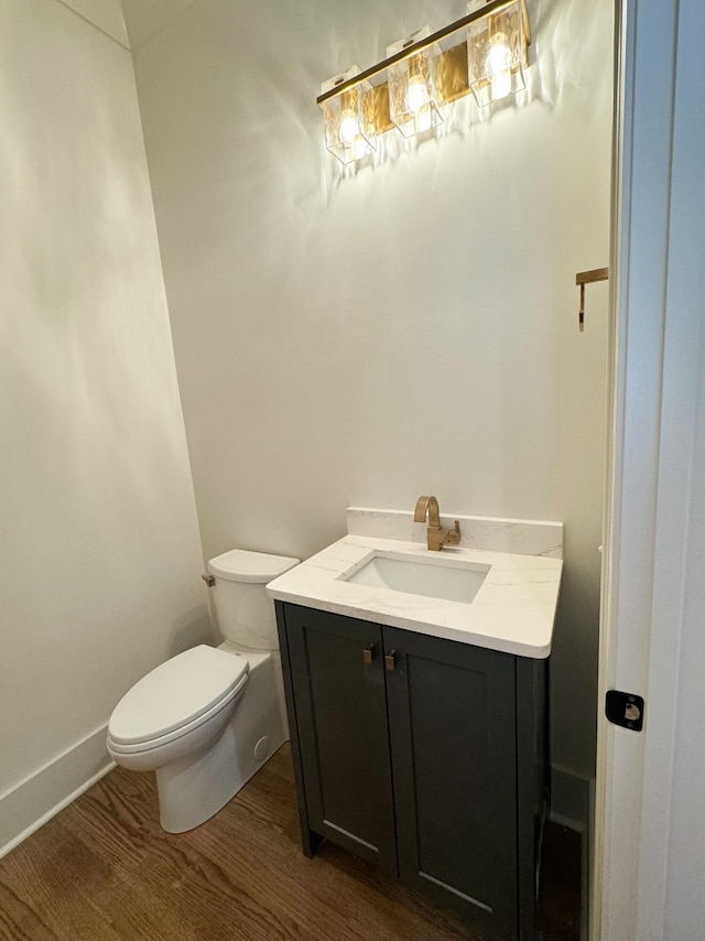 bathroom featuring vanity, hardwood / wood-style flooring, and toilet