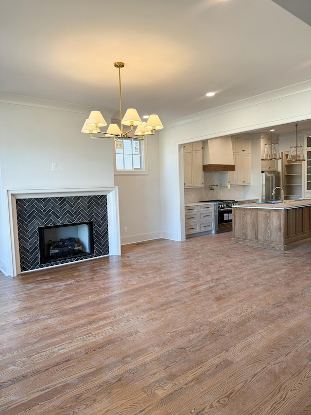 kitchen with decorative backsplash, custom exhaust hood, high end stove, decorative light fixtures, and hardwood / wood-style floors