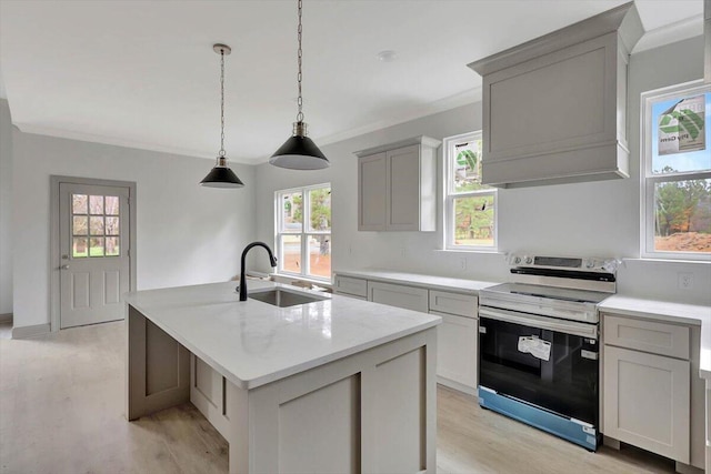 kitchen featuring light stone counters, a kitchen island with sink, sink, electric stove, and light hardwood / wood-style floors