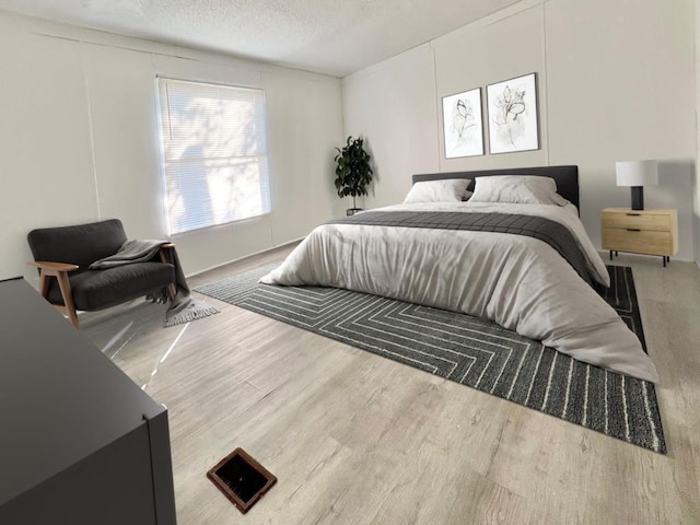 bedroom featuring wood-type flooring and a textured ceiling