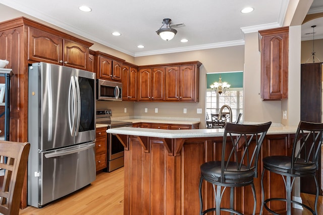 kitchen with a kitchen breakfast bar, crown molding, a notable chandelier, light hardwood / wood-style floors, and stainless steel appliances