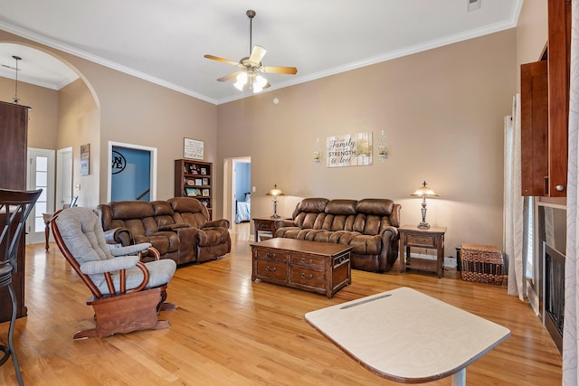 living room with light hardwood / wood-style floors, ceiling fan, and ornamental molding