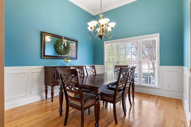 dining space featuring ornamental molding, plenty of natural light, a chandelier, and light hardwood / wood-style floors