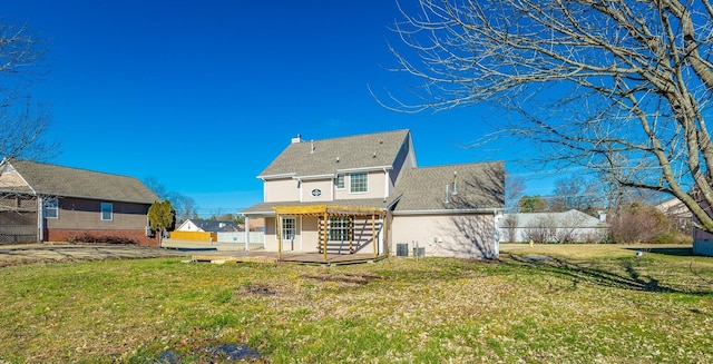 rear view of property featuring central AC and a lawn