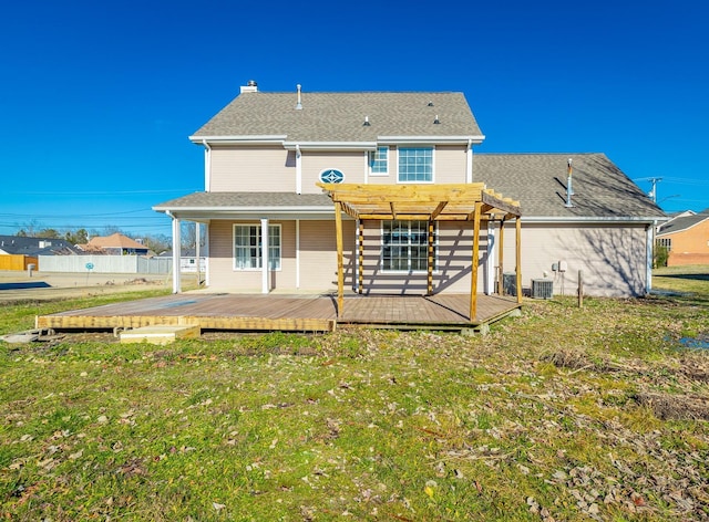 rear view of property with cooling unit, a deck, a pergola, and a yard