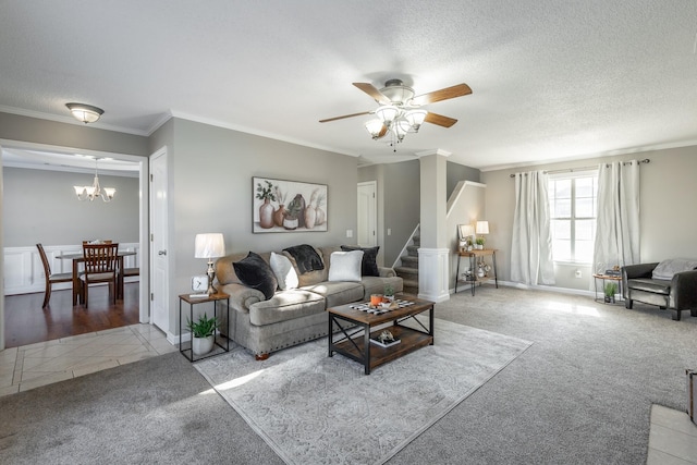 living room featuring ceiling fan with notable chandelier, a textured ceiling, carpet floors, and crown molding