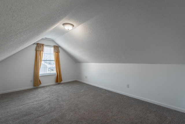 bonus room featuring lofted ceiling and dark colored carpet