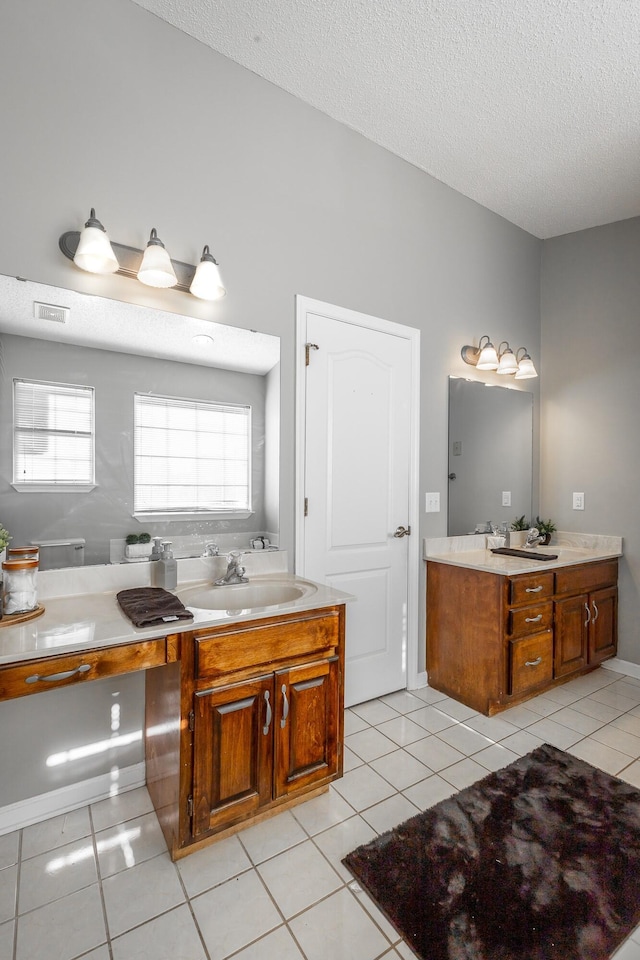 bathroom with tile patterned floors, vanity, and a textured ceiling