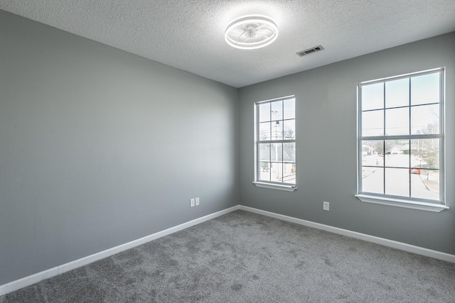 spare room featuring a textured ceiling and carpet floors