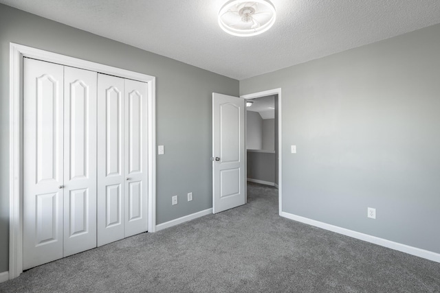 unfurnished bedroom featuring carpet, a textured ceiling, and a closet