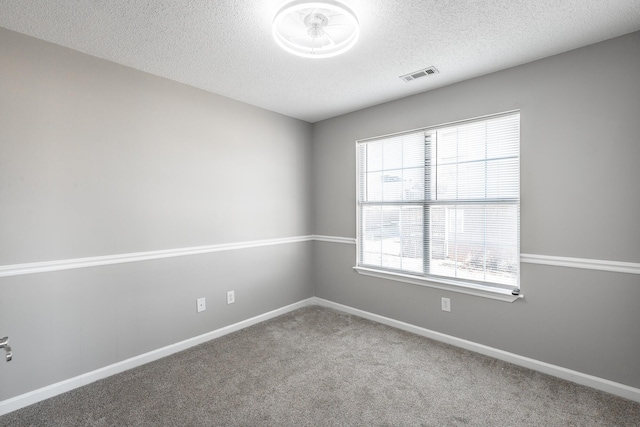 carpeted spare room featuring a textured ceiling