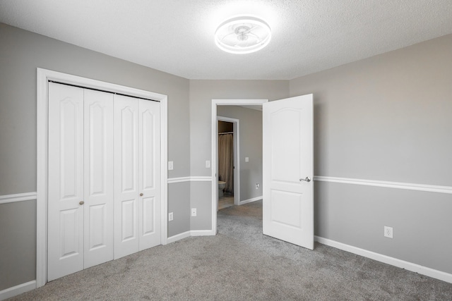 unfurnished bedroom featuring carpet flooring, a closet, and a textured ceiling