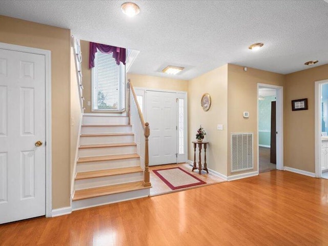 foyer featuring hardwood / wood-style floors and a textured ceiling