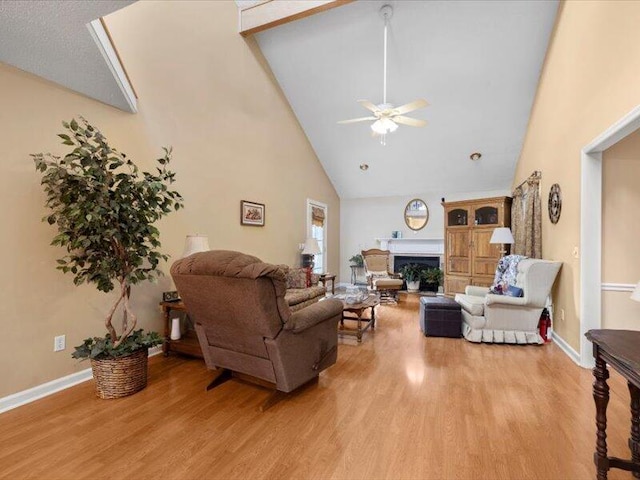 living room featuring ceiling fan, light hardwood / wood-style floors, and high vaulted ceiling