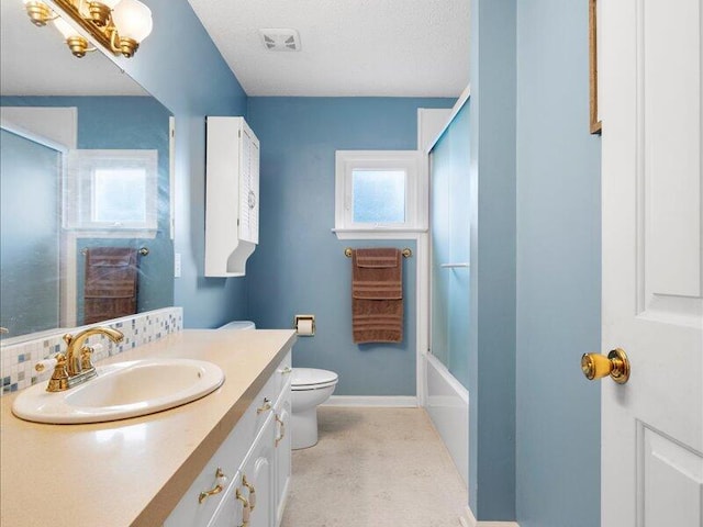 full bathroom with a textured ceiling, vanity, toilet, and bath / shower combo with glass door