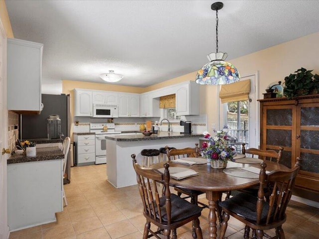 tiled dining area featuring a textured ceiling and sink