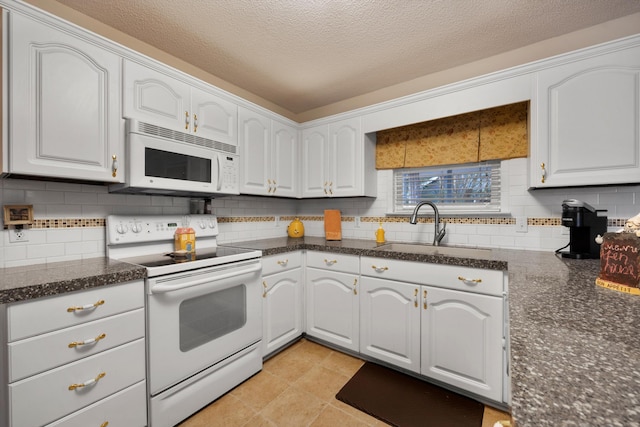 kitchen with white appliances, white cabinetry, and a sink