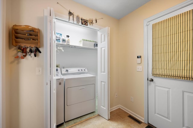 laundry room featuring light tile patterned floors, laundry area, visible vents, baseboards, and washer and dryer