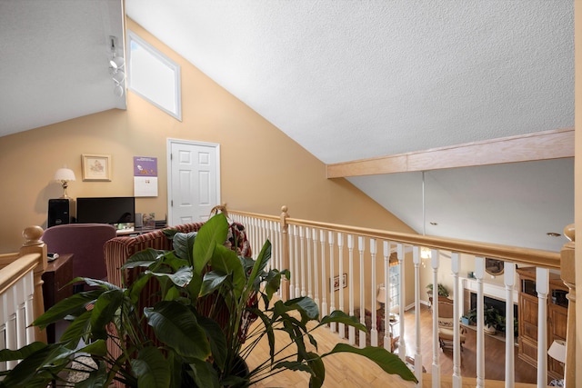 interior space with a textured ceiling, high vaulted ceiling, and light wood-style floors