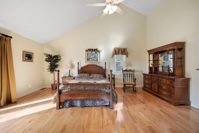 bedroom with baseboards, high vaulted ceiling, a ceiling fan, and light wood-style floors