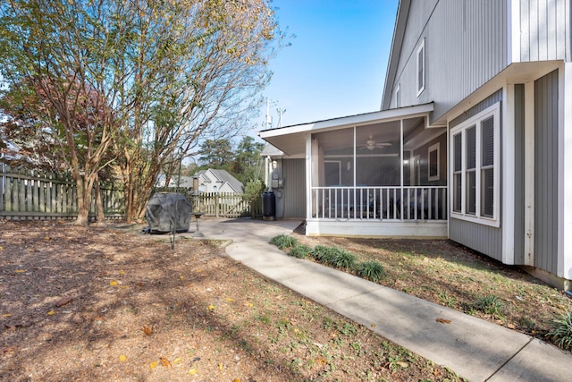 view of yard with ceiling fan, fence, and a sunroom