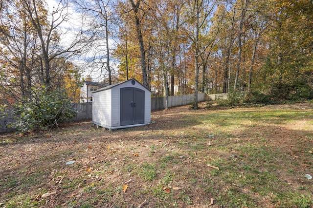 view of yard featuring an outbuilding, a storage unit, and a fenced backyard