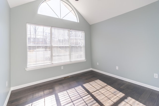 spare room with high vaulted ceiling, dark hardwood / wood-style floors, and a wealth of natural light