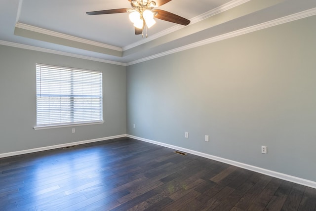 unfurnished room with dark hardwood / wood-style floors, ceiling fan, ornamental molding, and a tray ceiling