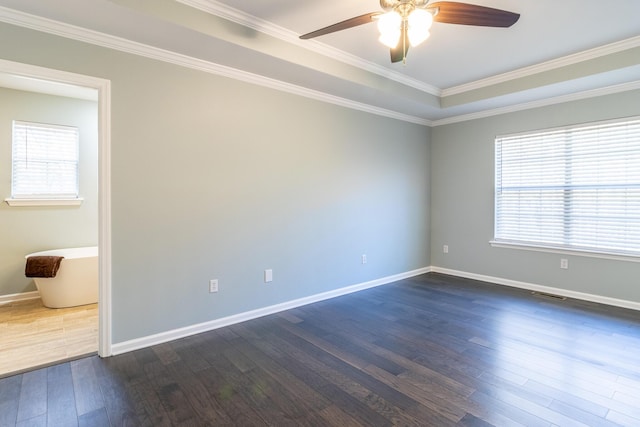 unfurnished room with a raised ceiling, crown molding, ceiling fan, and dark hardwood / wood-style floors