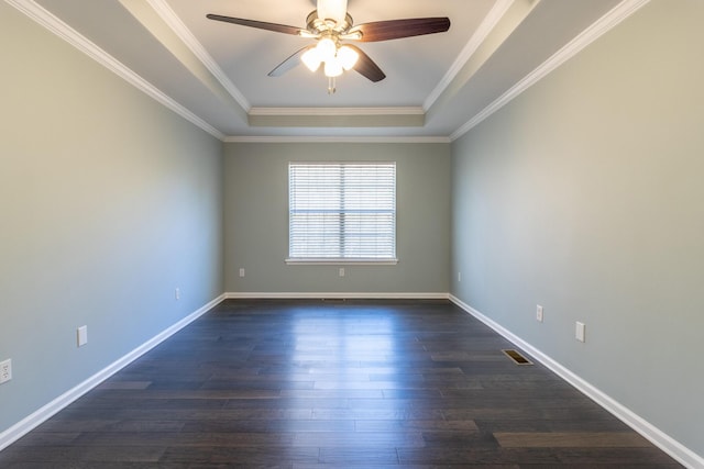 empty room with a tray ceiling, ceiling fan, dark hardwood / wood-style flooring, and crown molding