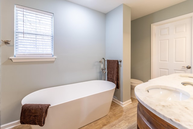 bathroom featuring toilet, a bathtub, vanity, and hardwood / wood-style flooring