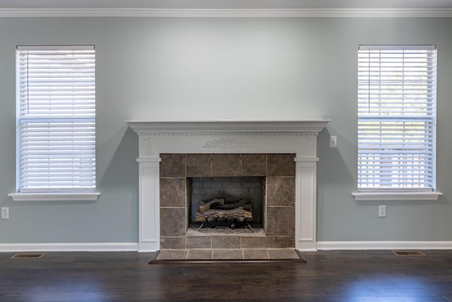 room details featuring a tile fireplace, hardwood / wood-style flooring, and crown molding