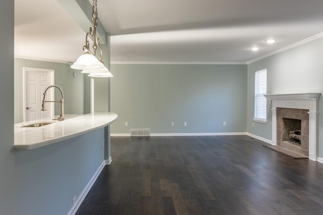 unfurnished living room featuring sink, a high end fireplace, dark hardwood / wood-style floors, and ornamental molding