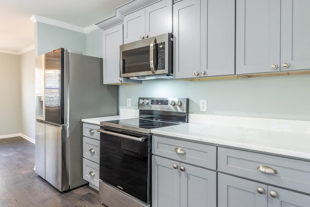 kitchen featuring appliances with stainless steel finishes, gray cabinets, dark hardwood / wood-style floors, and ornamental molding