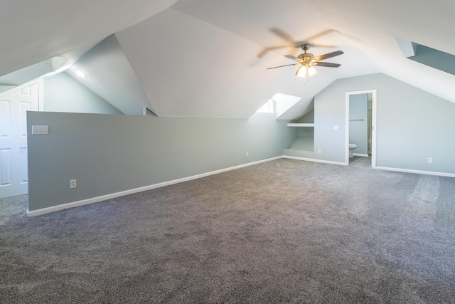 bonus room with dark colored carpet, vaulted ceiling, ceiling fan, and built in features