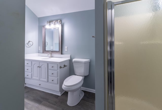 bathroom with a shower with door, vanity, hardwood / wood-style floors, and toilet