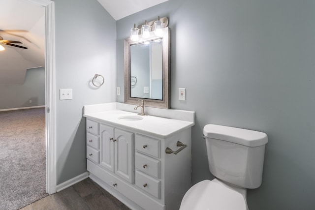 bathroom featuring ceiling fan, wood-type flooring, vaulted ceiling, toilet, and vanity