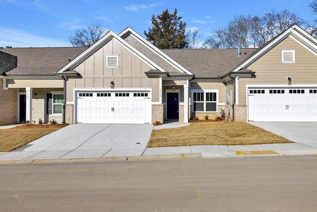 craftsman-style home featuring a garage, concrete driveway, brick siding, and board and batten siding