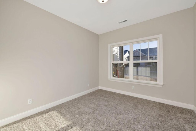 empty room featuring carpet, visible vents, and baseboards