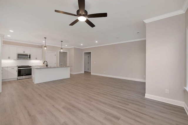 kitchen featuring a kitchen island with sink, white cabinetry, open floor plan, hanging light fixtures, and appliances with stainless steel finishes