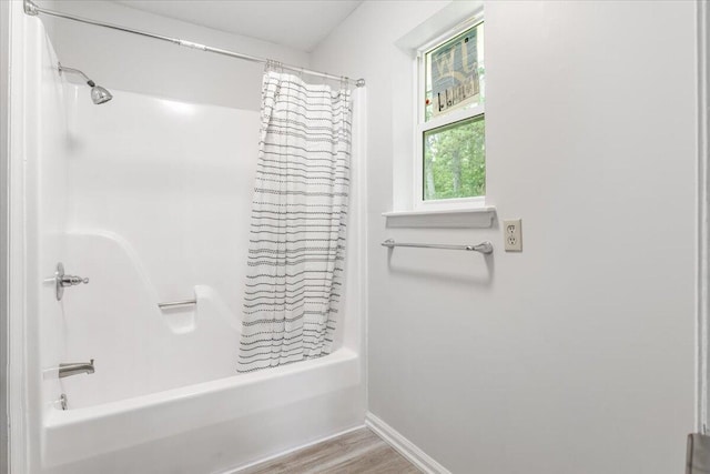 bathroom featuring shower / bathtub combination with curtain, baseboards, and wood finished floors