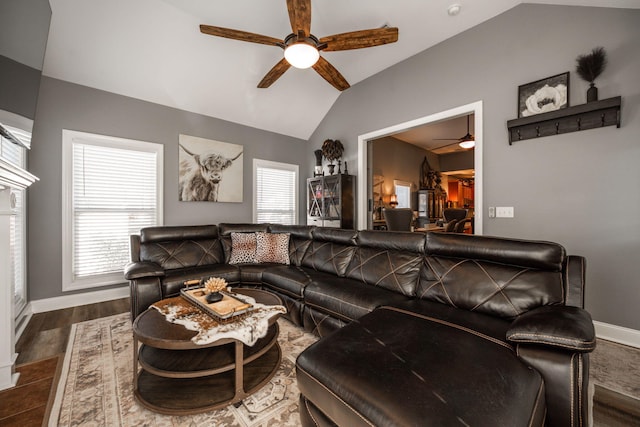 living room featuring a healthy amount of sunlight, dark wood-type flooring, ceiling fan, and lofted ceiling