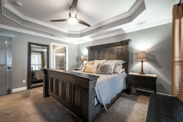 bedroom with ceiling fan, ornamental molding, ensuite bathroom, and a tray ceiling