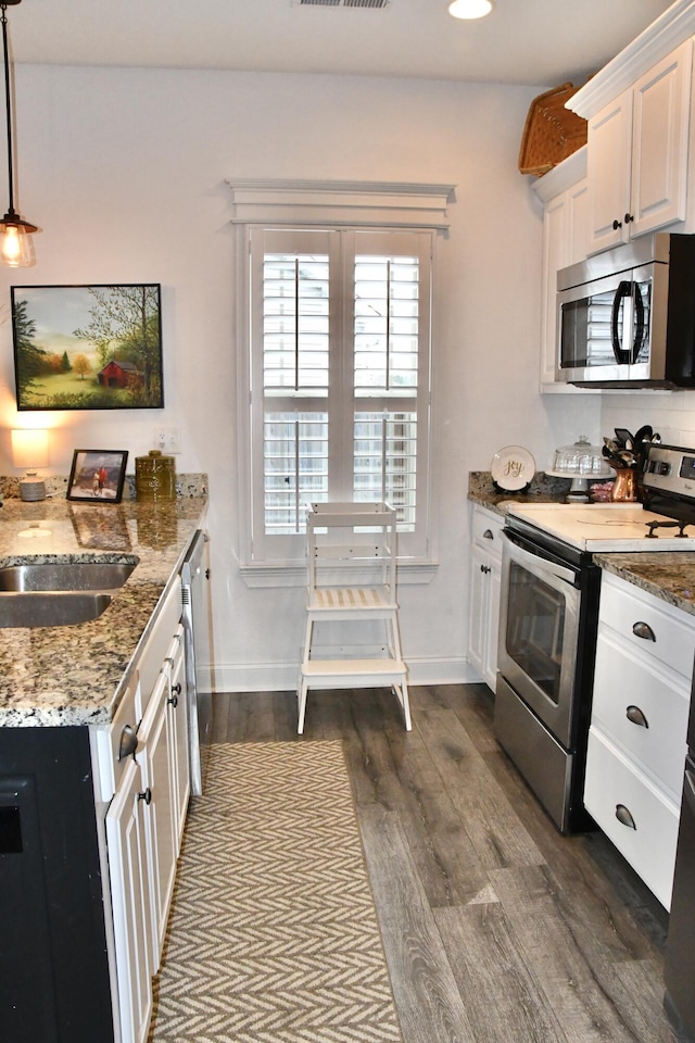 kitchen featuring stone counters, white cabinets, hanging light fixtures, dark hardwood / wood-style flooring, and stainless steel appliances